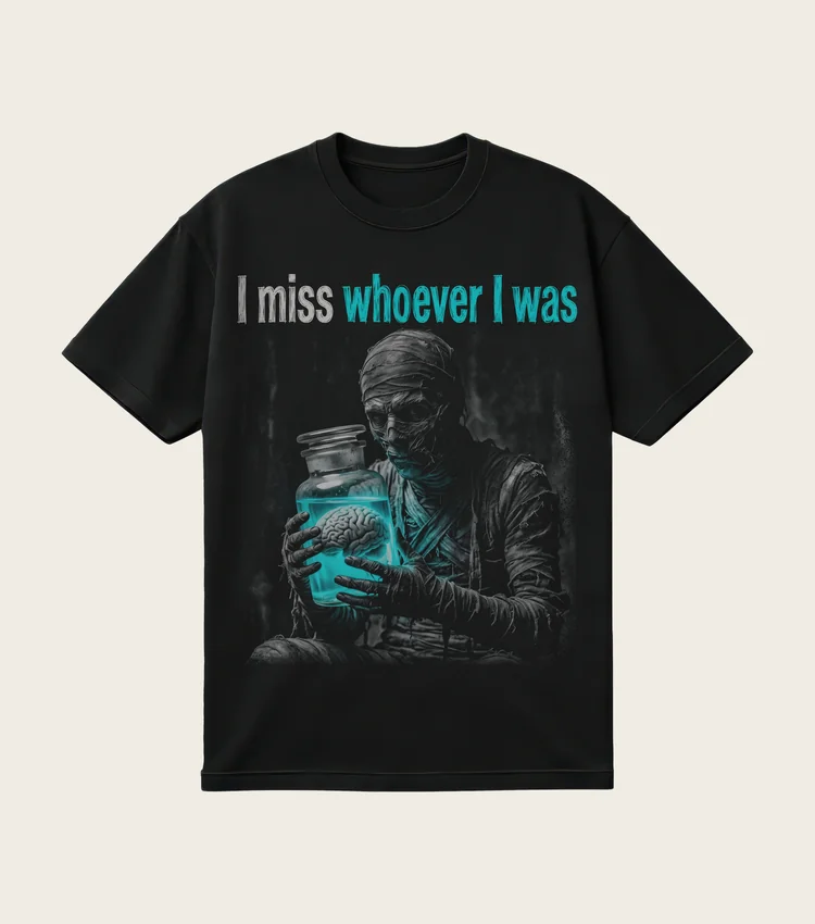 I Miss Whoever I Was printed on a black t-shirt, laid flat
