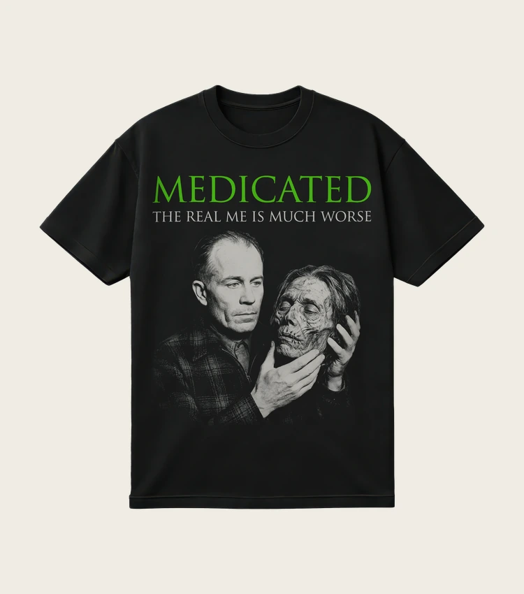 Medicated: The Real Me Is Much Worse printed on a black t-shirt, laid flat